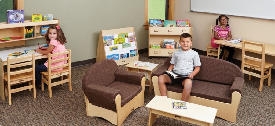 3 children using wooden classroom tables and chairs