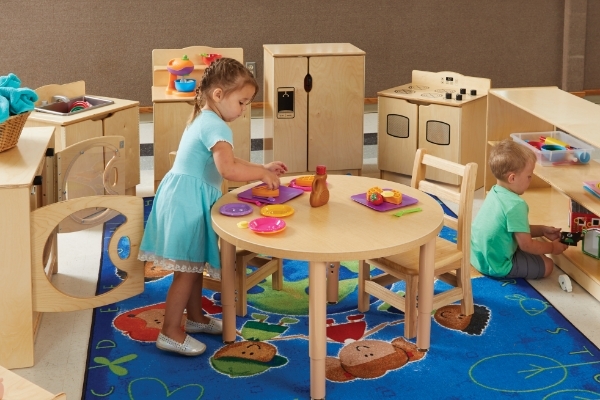 young boy and girl using dramatic play furniture